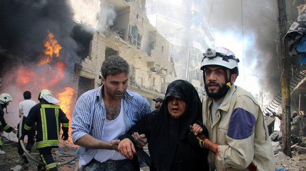 In this photo taken on June 8, 2016 provided by the Syrian Civil Defense Directorate in Liberated Province of Aleppo, which has been authenticated based on its contents and other AP reporting, shows Syrian civil defense workers, right, helps an injured woman after warplanes attacked a street, in Aleppo, Syria. After four years of grinding battles, Aleppo’s divided residents face a common fear as the prospect of a total siege looms. Syria’s largest city used to be its economic locomotive, now it is has become an emblem of its stalemated civil war. (Civil Defense Directorate in Liberated Province of Aleppo via AP)