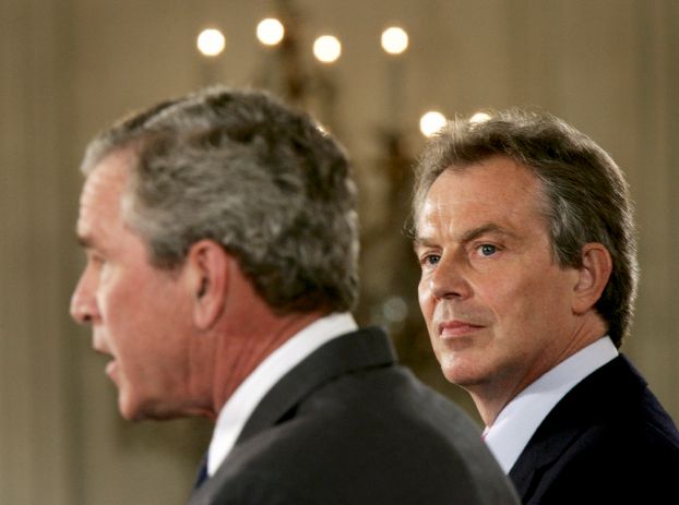 British Prime Minister Tony Blair (R) looks at U.S. President George W. Bush at a joint news conference in the East Room of the White House in Washington June 7, 2005.  REUTERS/Jason Reed/File Photo